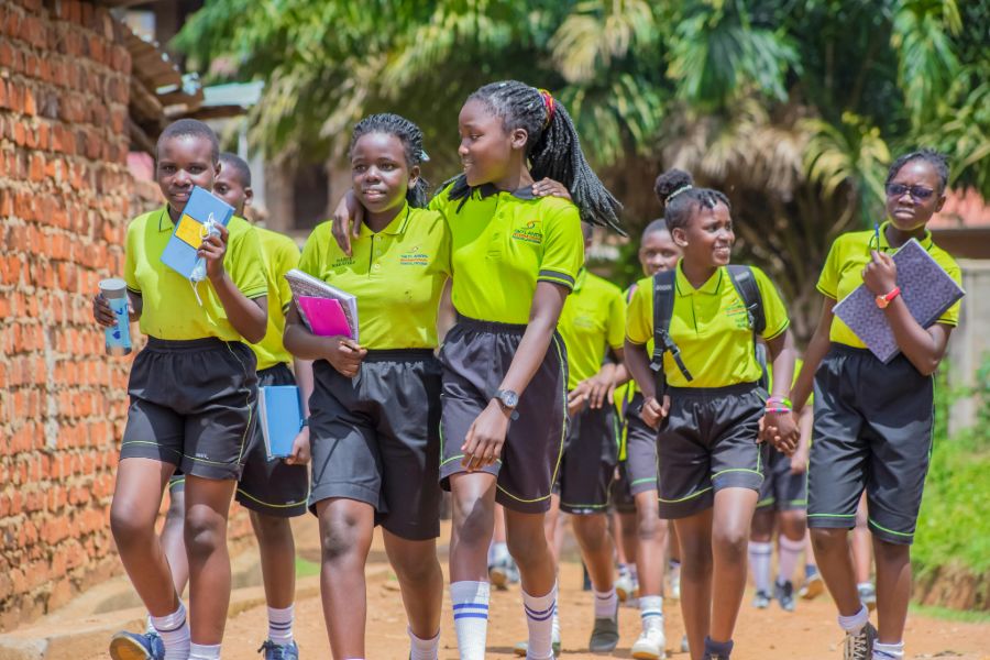 A group of school children walking down a street in Africa.
