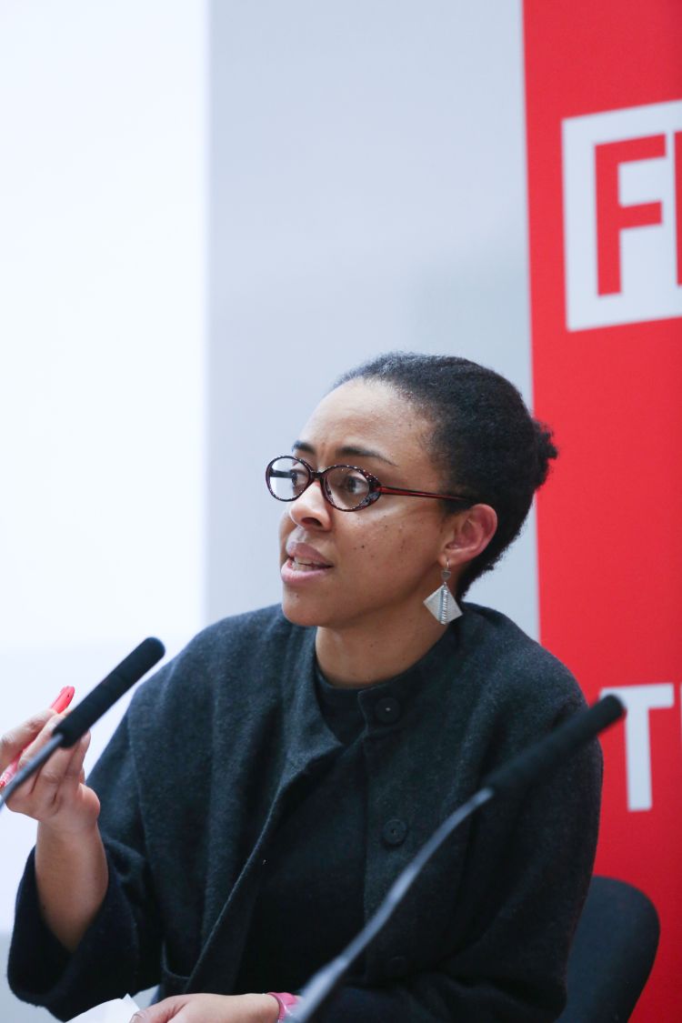 Dr Simidele Dosekun speaking into a microphone at an LSE event.
