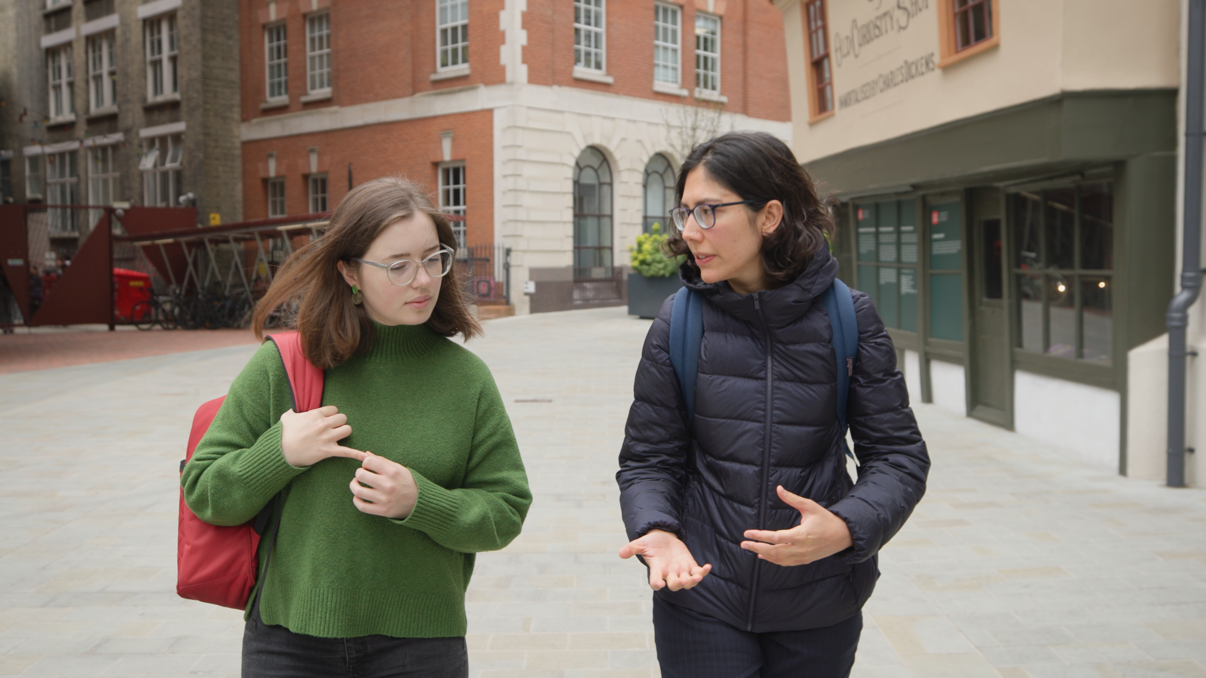 LSE alumnae Maddie Diment and Ria Sen talking to one another outside of the Old Curiosity Shop.