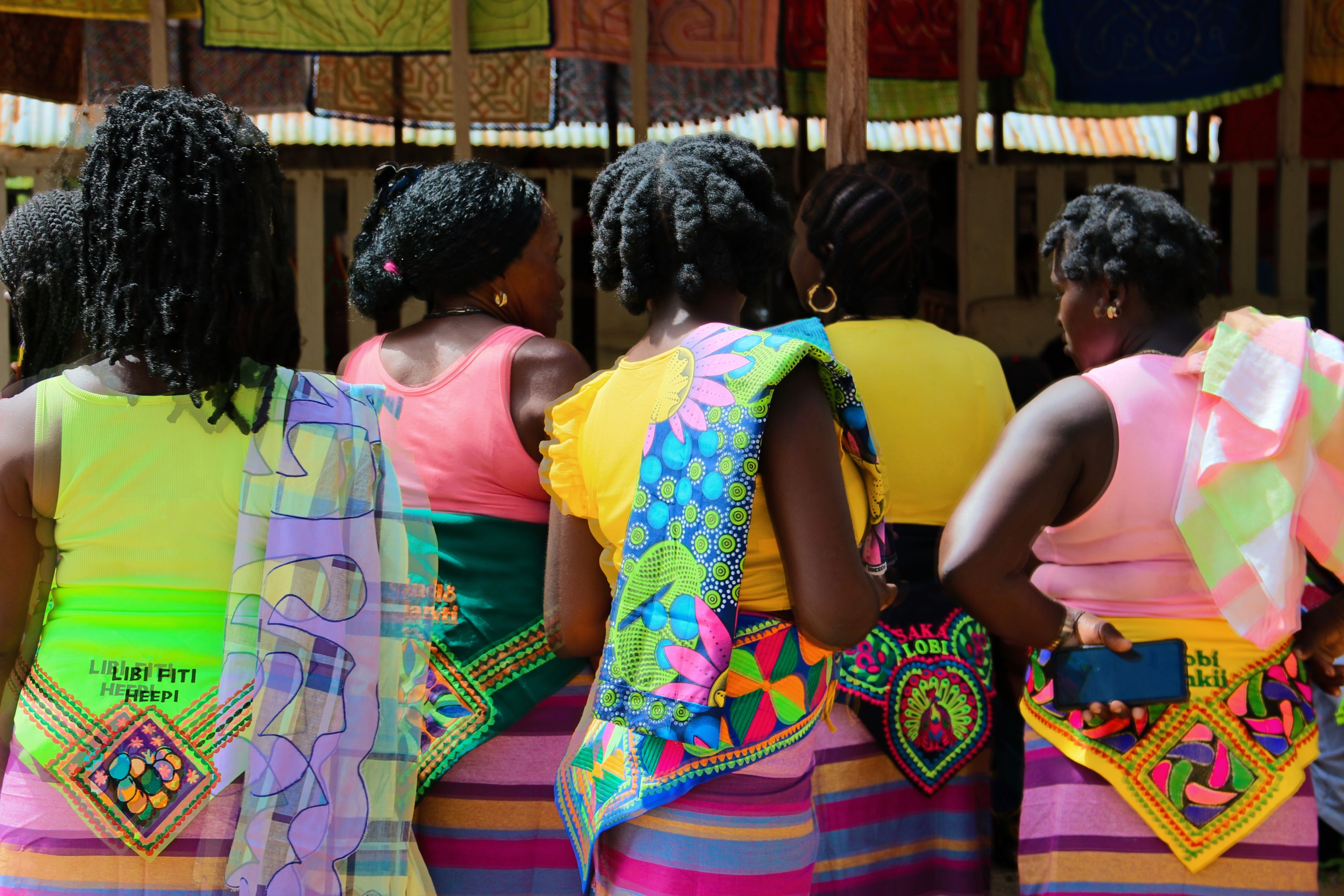 Women wear brightly coloured clothing during a local ceremonial event